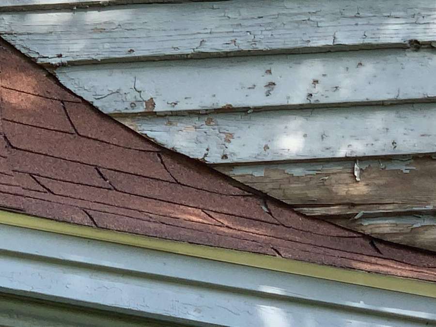 Where a small shingled roof meets the wood siding on a Watertown home