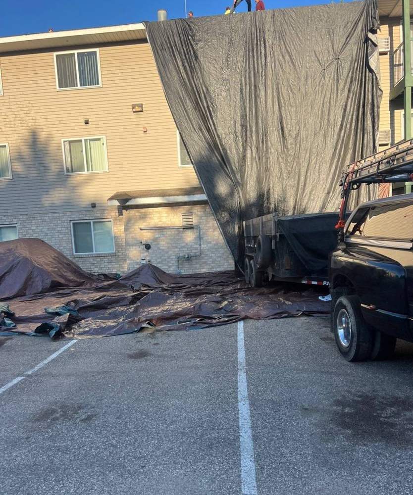Loading a debris trailer during a multi-family roof tear-off in Hutchinson, October 2024