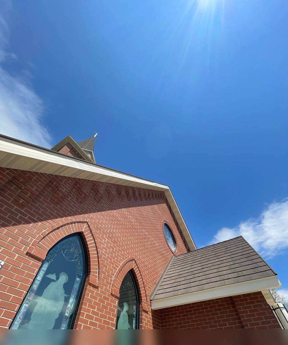 Steeple and gothic roofline of St. Stanislaus Kostka Church in Bowlus, photographed during a roof inspection, May 2022