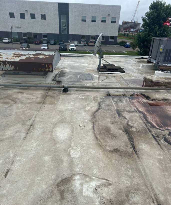 Dark ponding stains on the old membrane roof of the Bloomington Lincoln dealership in Bloomington, MN, July 2024