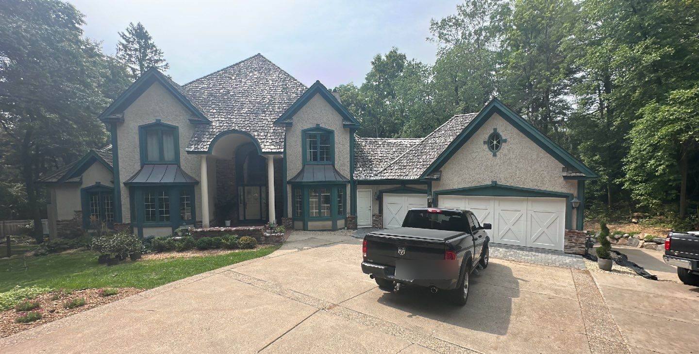 European-style stucco home in Hopkins, MN with a weathered cedar shake roof, photographed by Repair King during a 2023 roof inspection