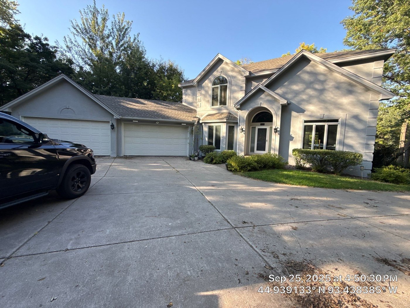 Two-story stucco home with a three-car garage in Minnetonka, photographed during our September 2025 hail inspection