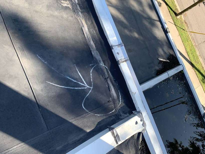 Chalk arrows marking damage near the roof edge at Washington Place, St. Cloud