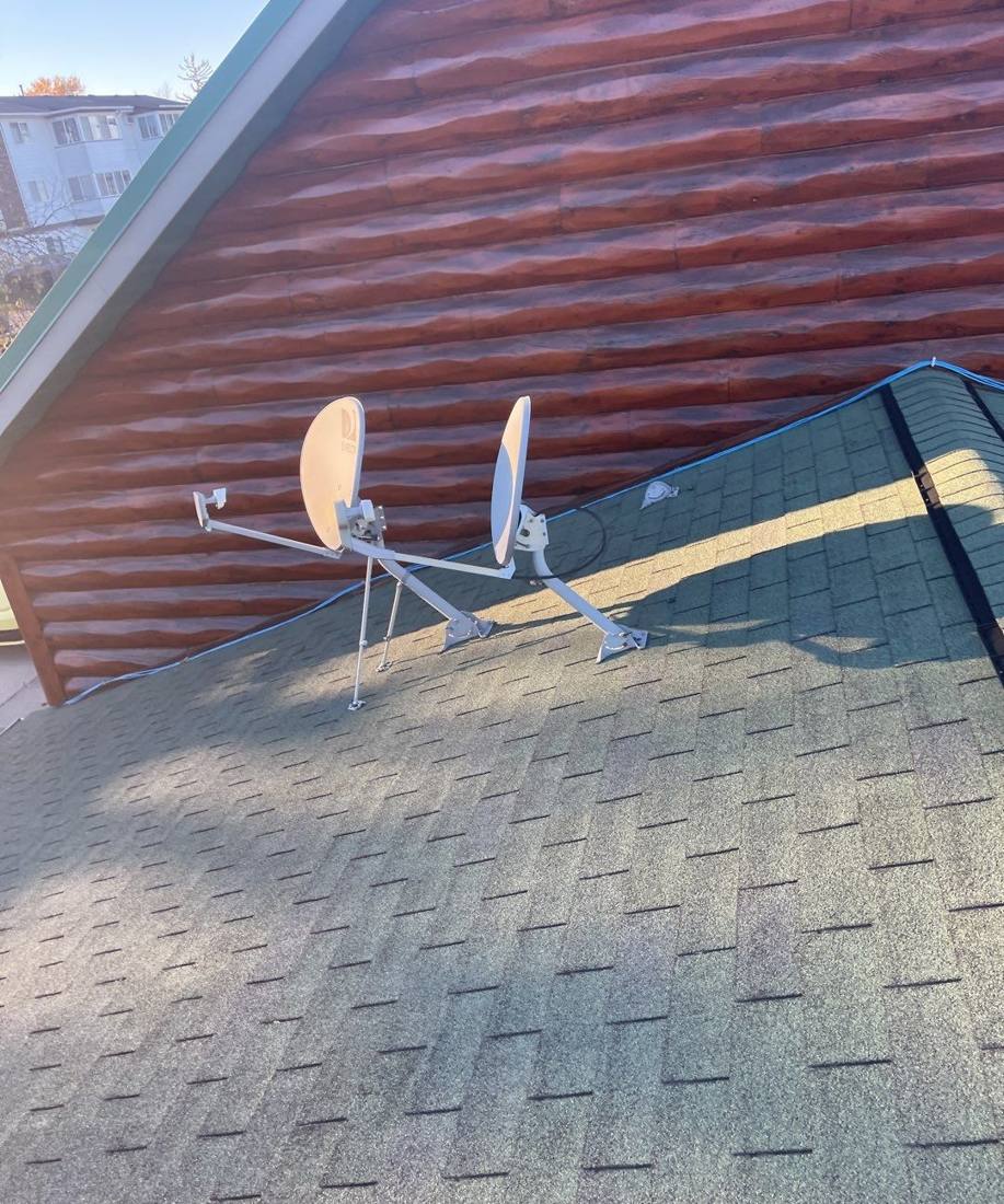 Satellite dishes mounted on a log-sided roofline at a Lake City lakefront property, October 2021