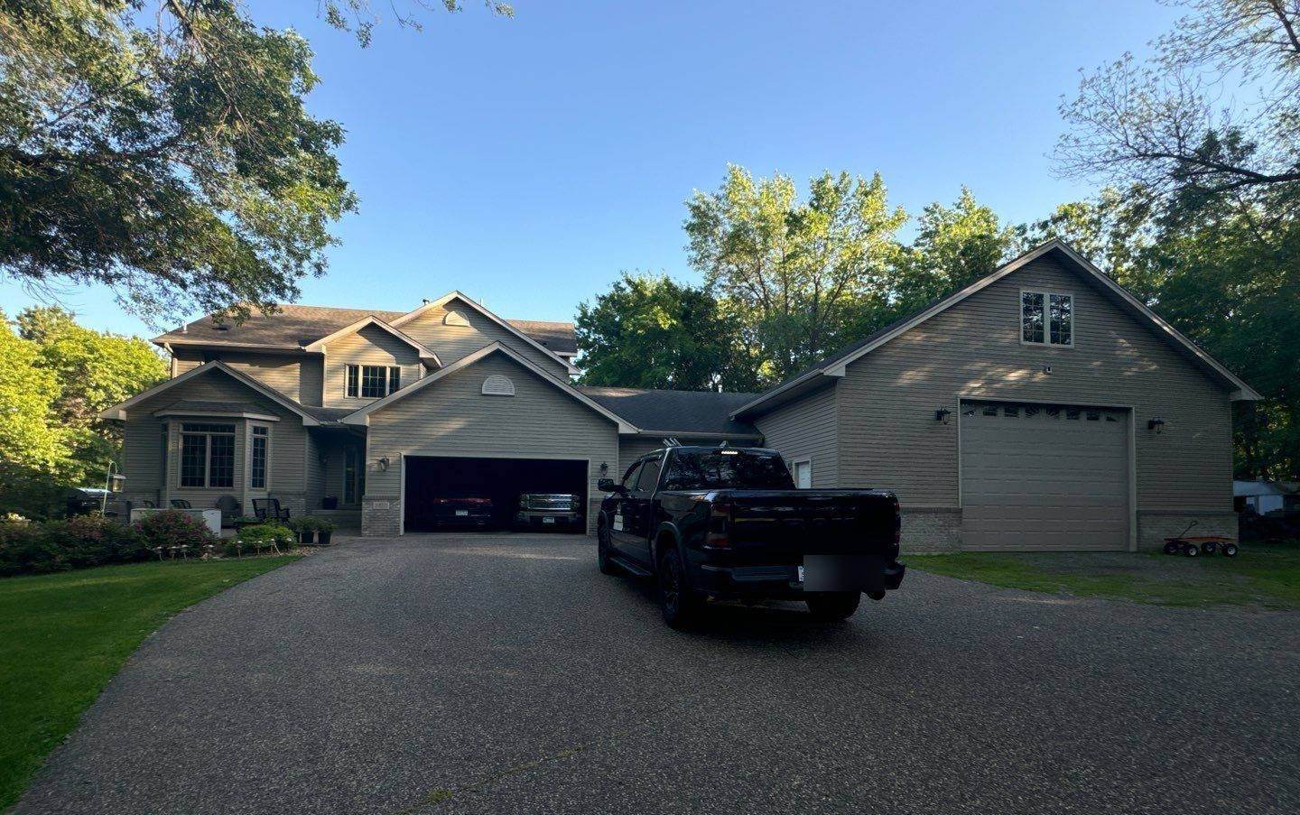 Two-story home with attached garages in Oak Grove, MN photographed by Repair King during a roof project, June 2024