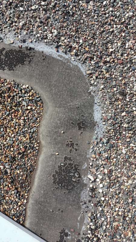 A ponding ring on the old gravel roof at Forest Lake Chrysler Jeep Dodge, in Forest Lake, before Repair King replaced it