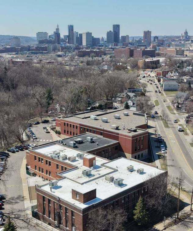 Aerial view over a commercial roof near Payne Avenue with the downtown St. Paul skyline in the background, April 2026