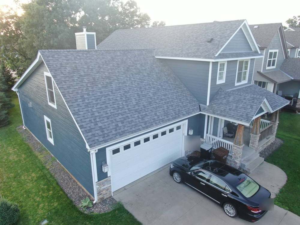 Drone view of a Ramsey, MN two-story home finished with blue LP SmartSide lap siding and a new shingle roof, August 2019