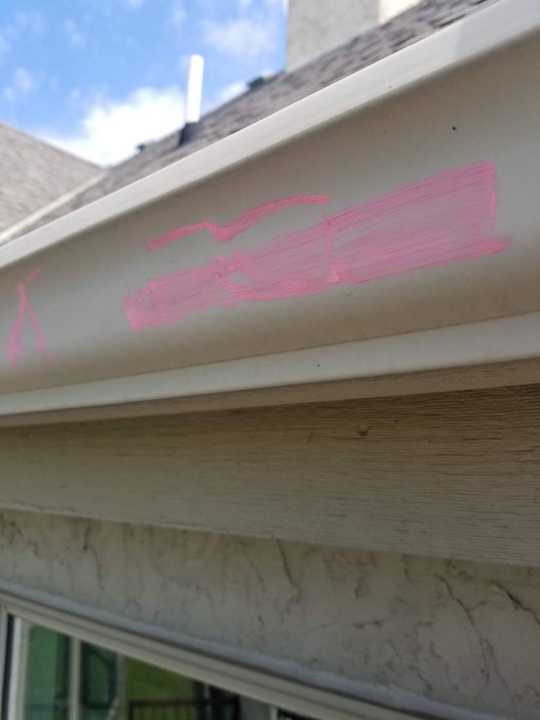 Chalk marks showing dents along a gutter on a Prior Lake home, May 2018
