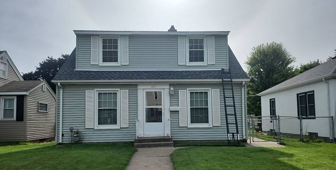 Two-story South St. Paul home with a new roof and ladder still up, July 2023