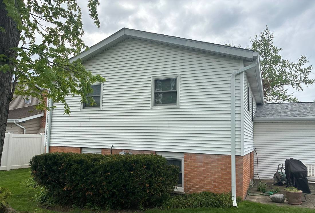 Vinyl siding checked for hail damage during a Darien inspection, April 2026
