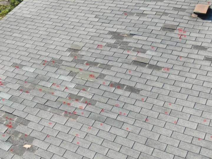 Drone photo of a Twelve 501 apartment roof slope in Burnsville with software-flagged marks and older shingle patches, May 2023