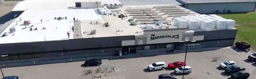 Drone view of Repair King crews replacing the roof of The Marketplace grocery store in Cokato, MN, July 2024