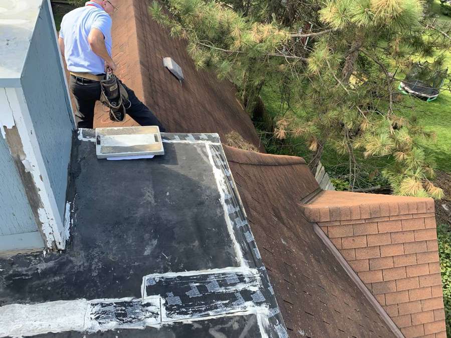 Low-slope roof section where it meets the shingled roof on an older Watertown home