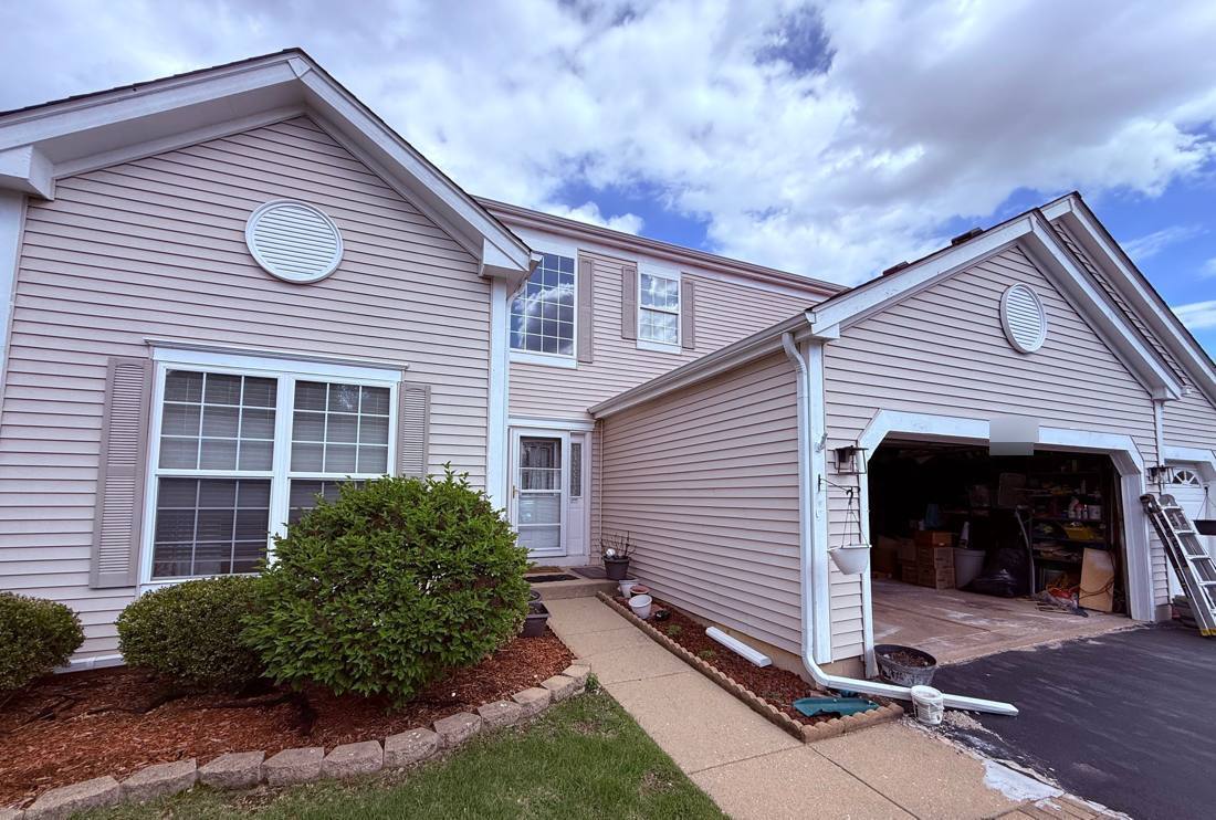 Two-story townhome on Primrose Lane in Bolingbrook during a siding project, May 2026