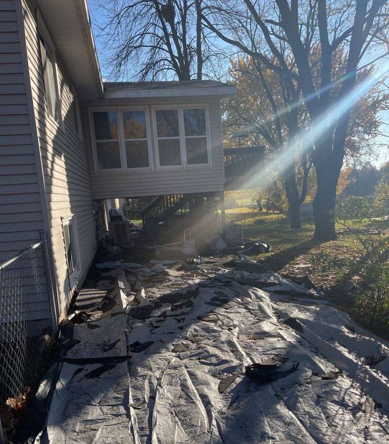 Tarps along the side of a Buffalo home during a roof tear-off, October 2021