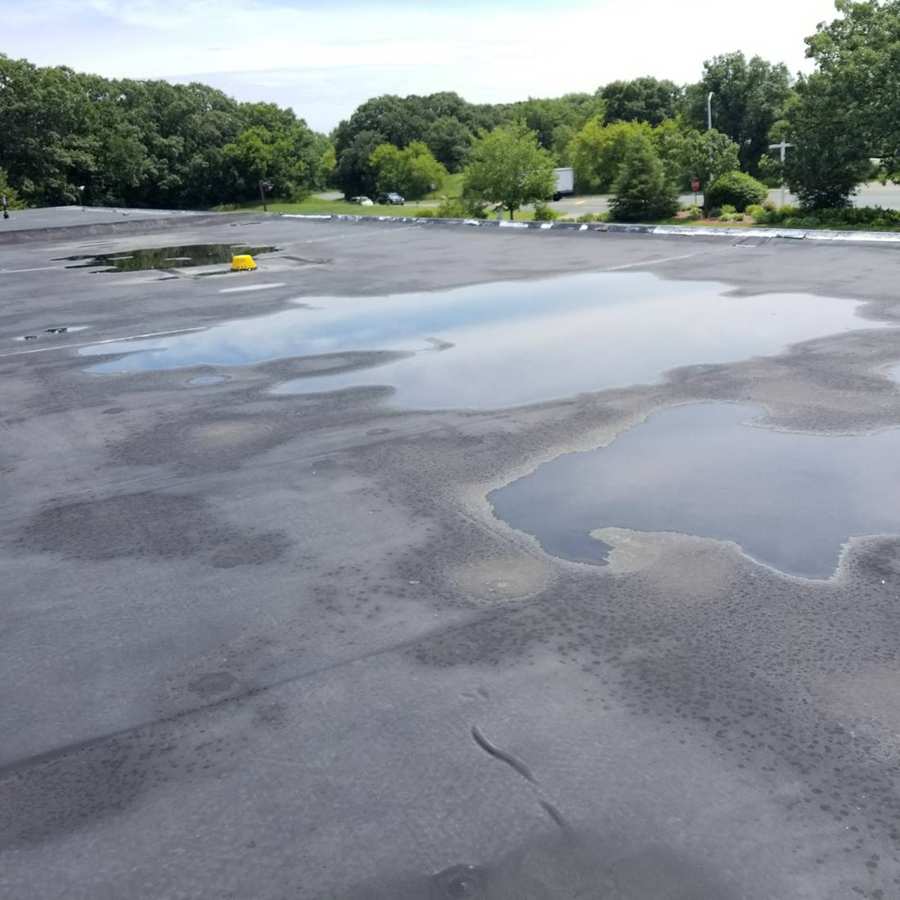 Standing water across the flat rubber roof of King of Glory Lutheran Church in Blaine, MN, during Repair King's July 2017 inspection
