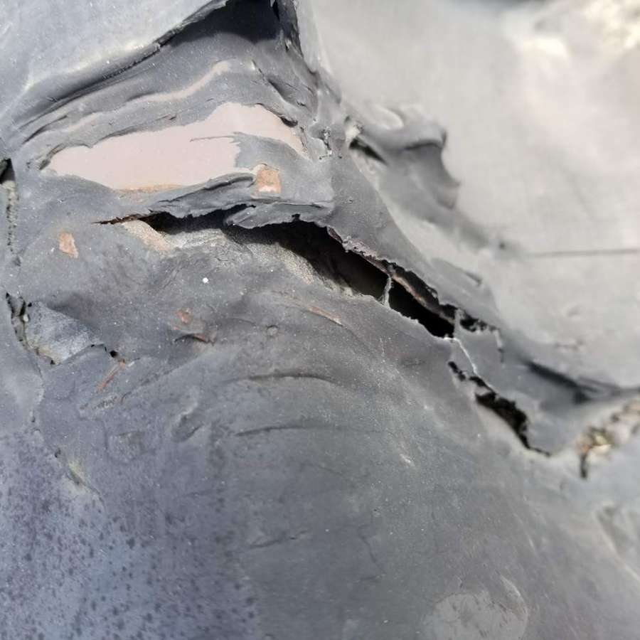 Torn and split EPDM membrane at a curb corner on the Little Caesars strip center roof in West St. Paul, MN