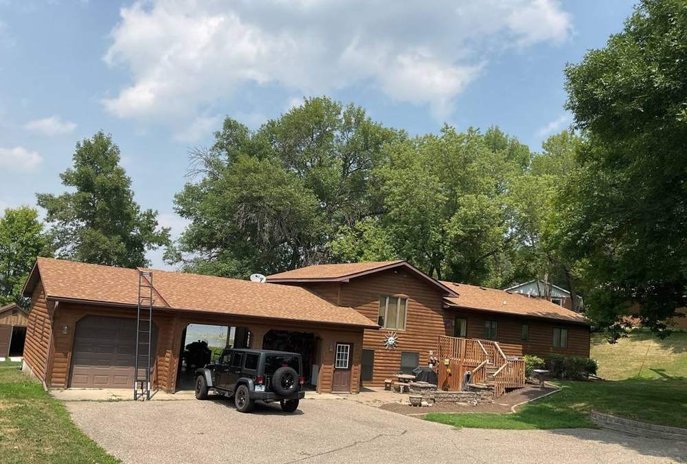 Log-sided home with an attached garage near Dassel, photographed in July 2023