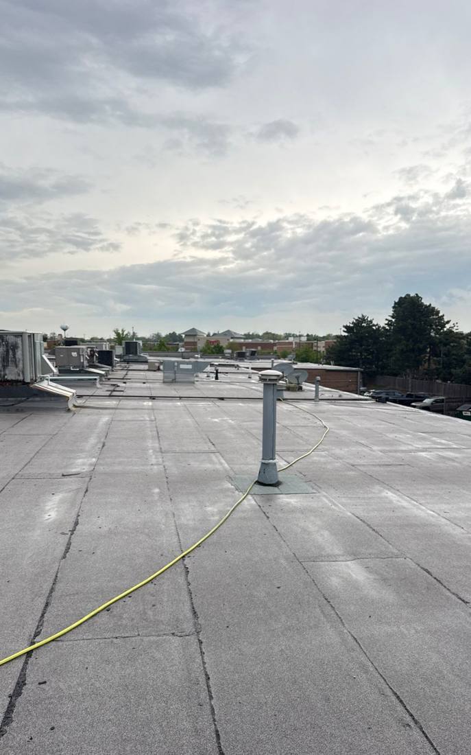 Rooftop view across a Hinsdale commercial roof toward neighboring buildings, April 2026