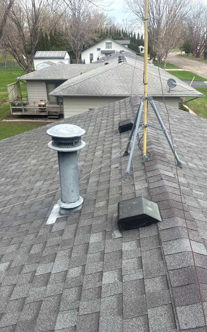 View across a Faribault neighborhood roofline during an inspection, April 2026