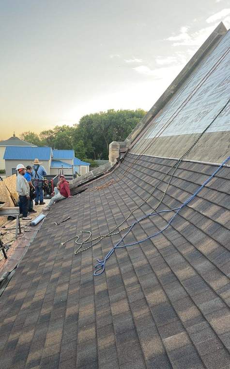 Crew and materials below the new shingle roof at St. Paul's Lutheran in St. James at the end of the first day, July 2023