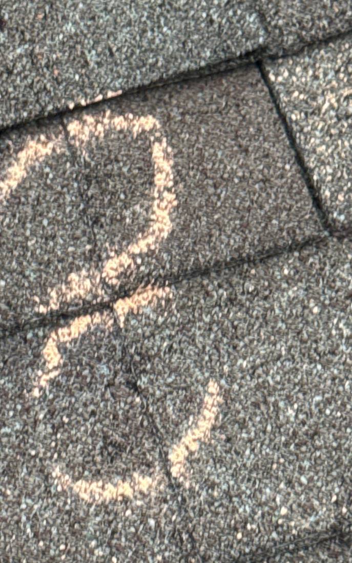 Hail hits chalk-marked in a cluster on a Plainfield roof slope, April 2026