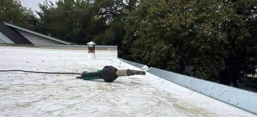 Heat-welding a membrane seam on a flat commercial roof near Snelling Avenue, Minneapolis, September 2026