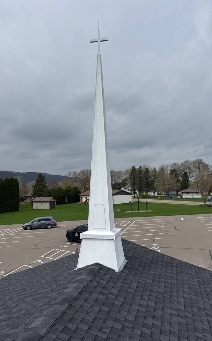 Valleyview Assembly of God's white steeple rising from the shingle roof in Lake City, MN, photographed by Repair King from the roof in April 2026