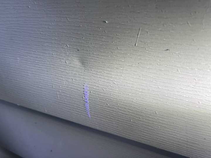 Another marked dent on the lap siding of the New Prague home, August 2021