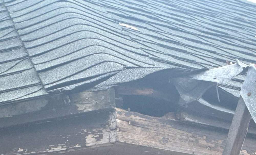 Layered old shingles over a deteriorated wood eave on a detached garage in St. Cloud, MN, photographed by Repair King in September 2025