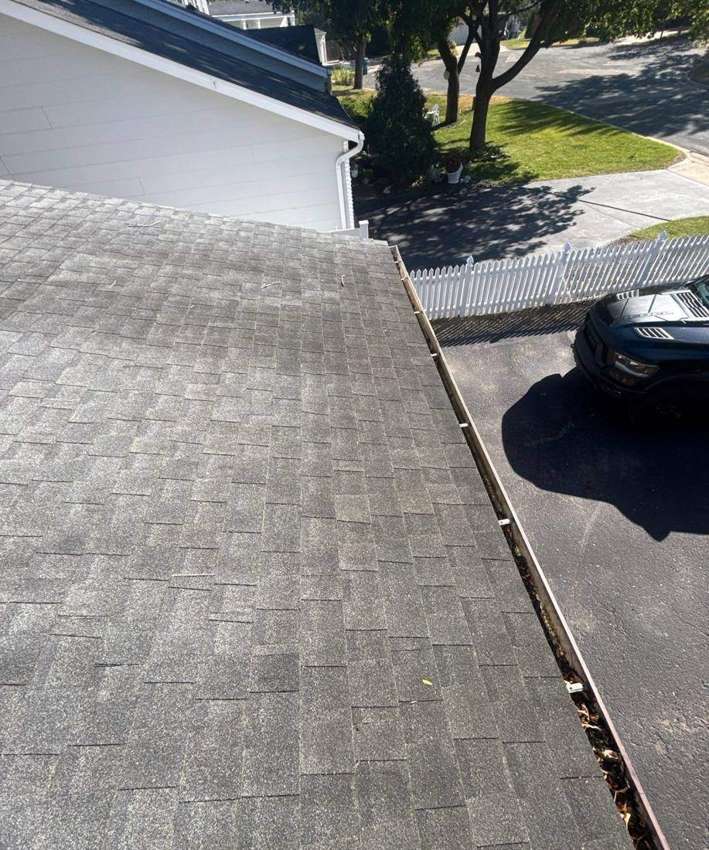 View down a Burnsville roof edge and gutter line toward the street, October 2025