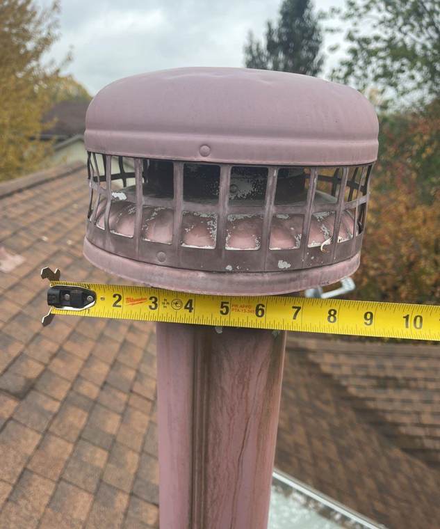 Tape measure across a dented roof vent cap on a Wyoming home, October 2021