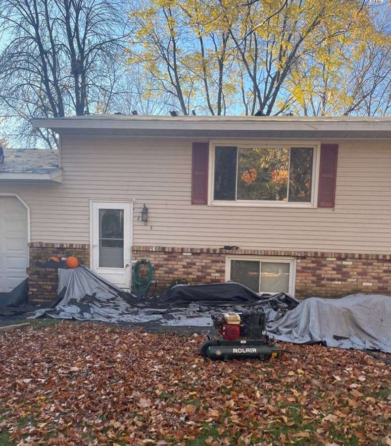 Tarps laid out around a split-level home in Buffalo, MN during a Repair King roof tear-off, October 2021