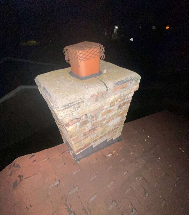Brick chimney and shingle roof during a night inspection in Buffalo, October 2021