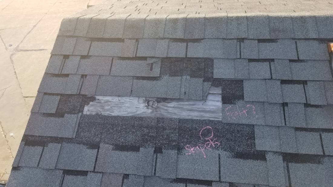 Damaged shingle section with chalk marks on the Mega Coin Laundry roof, Fairmont