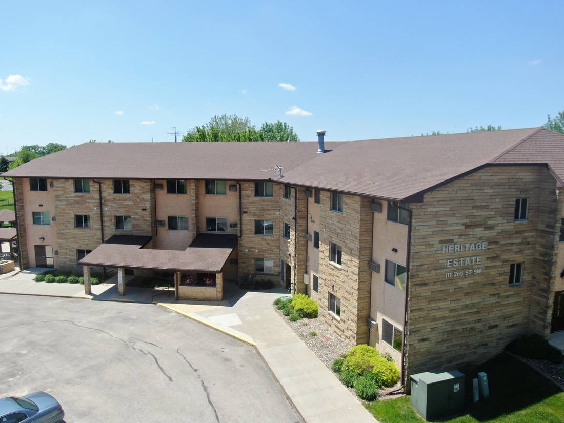 Heritage Estates apartment building in Dodge Center, MN, with its brown shingle roof, stone facade and covered entry