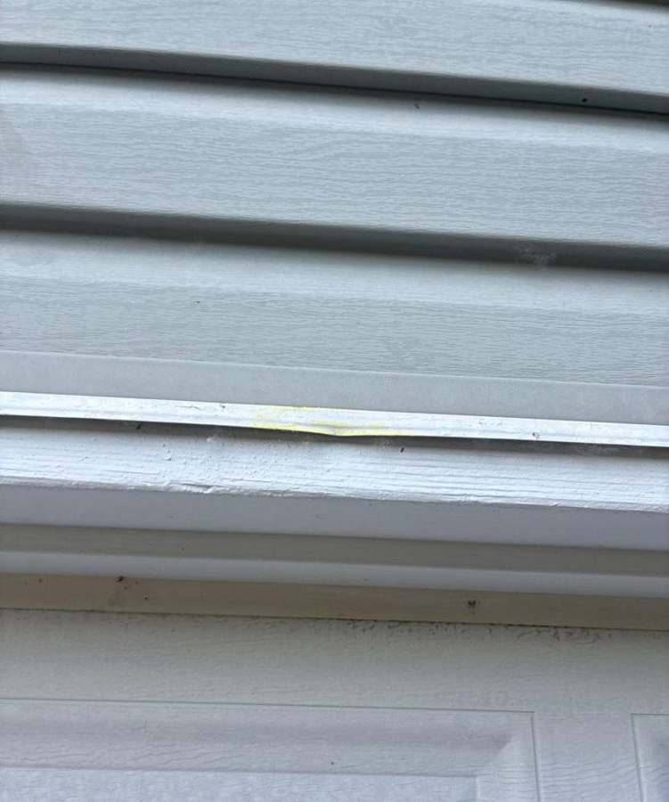 Cracked trim above a garage door on a Suzanne Avenue rambler in Shoreview, June 2026
