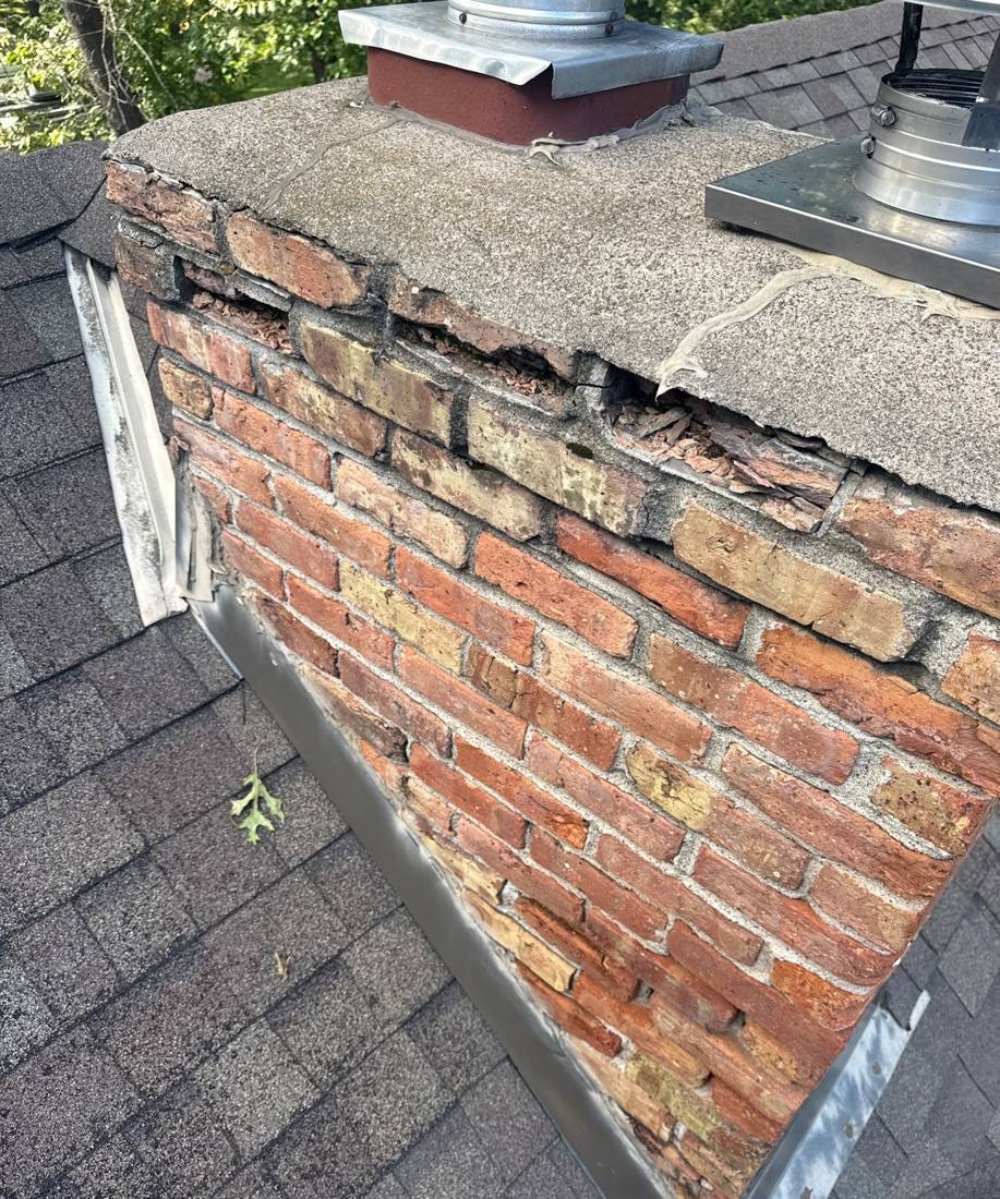 Cracked chimney flashing and open brick joints found on a Cottage Grove roof inspection, September 2025