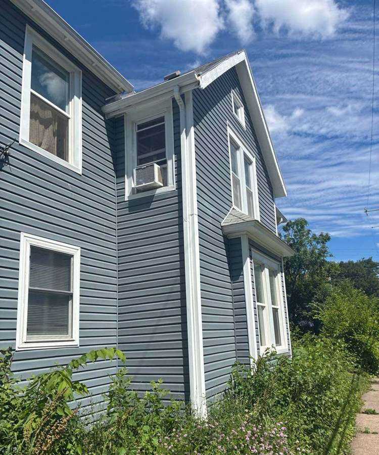 Blue two-story home on Isabel Street West photographed during a St. Paul inspection, June 2026