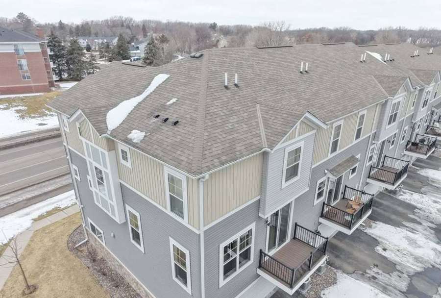 Drone view of a Lexington Woods townhome building's shingle roof and connected units in Roseville, MN, photographed by Repair King in February 2026