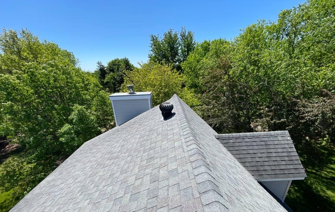 Aerial view of a Pine Island roofline and chimney chase during an inspection, June 2022