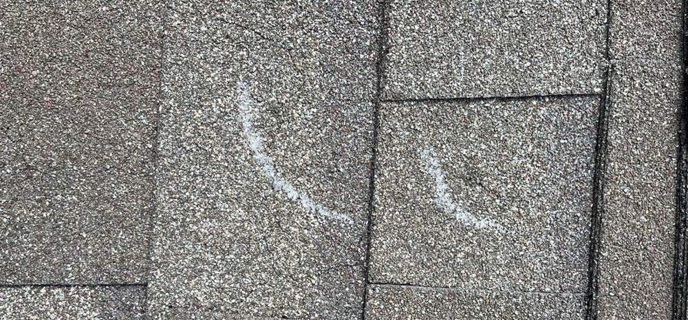 Cracked shingle tabs found during a roof inspection in Waverly, July 2023