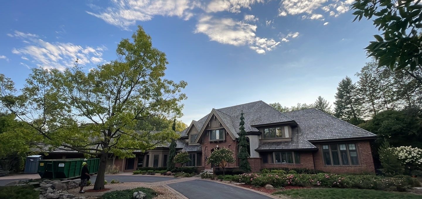 Brick and cedar shake estate home with a circle drive near Lake Minnetonka, photographed by Repair King in August 2023