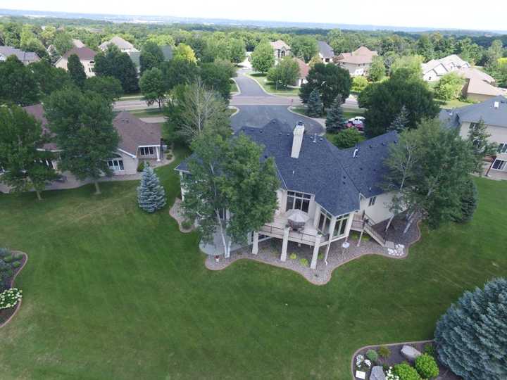 Drone view of the back of a stucco home and deck on a golf course in Prior Lake, MN, July 2018