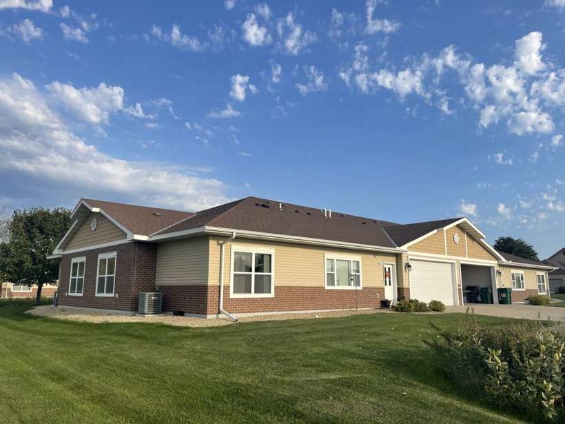 Pinecone Villas townhome with brick and tan siding and attached garages in Sartell, MN, photographed by Repair King in September 2021