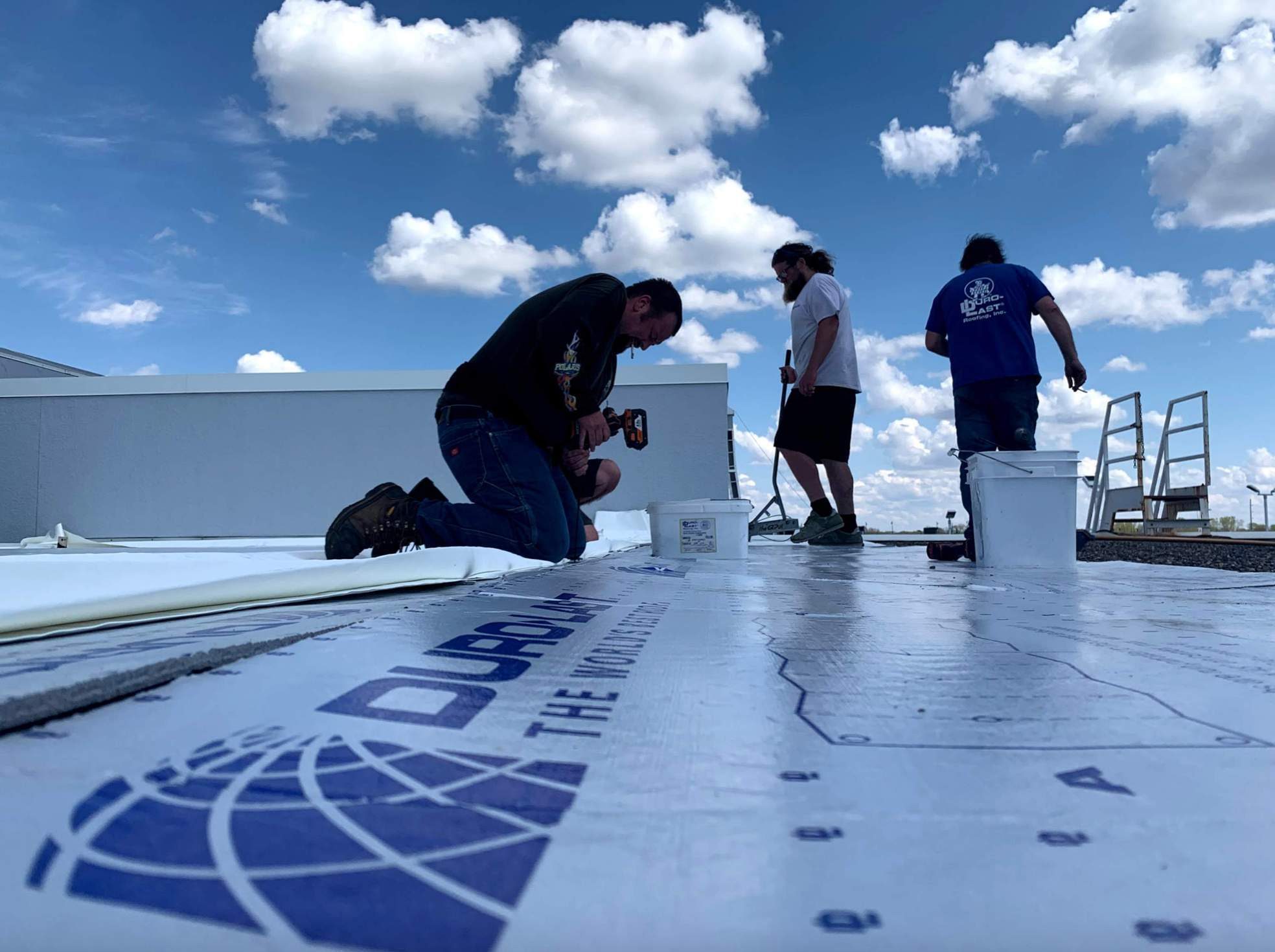 Repair King crew fastening a Duro-Last PVC membrane on a commercial flat roof