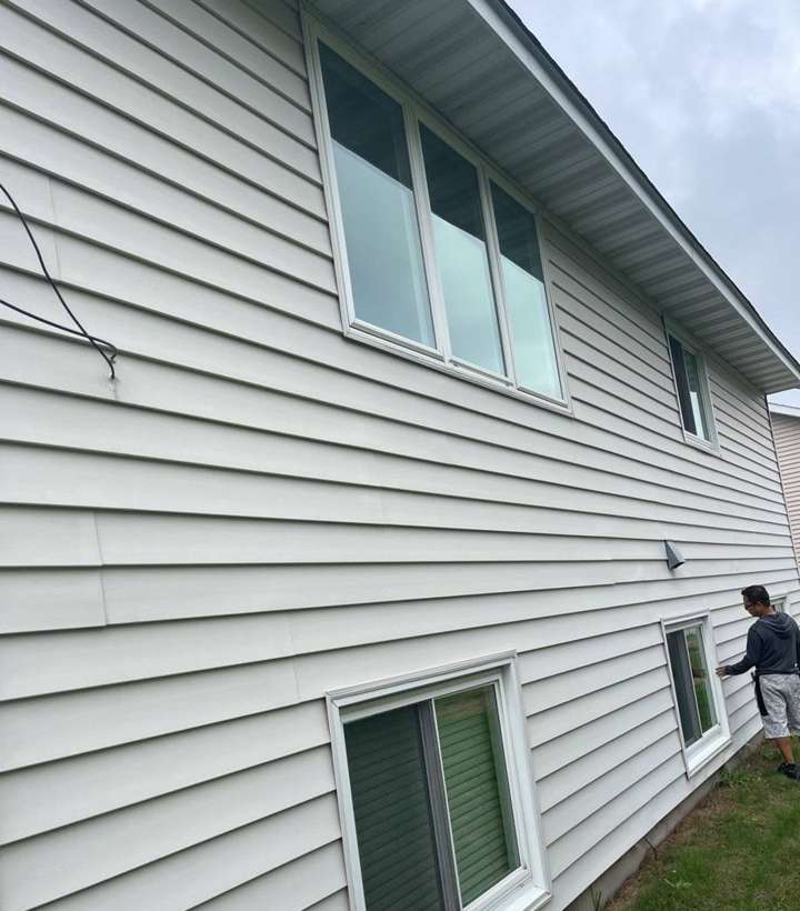 Repair King inspector checking the vinyl siding and windows on a two-story home in Sauk Rapids, MN, October 2021