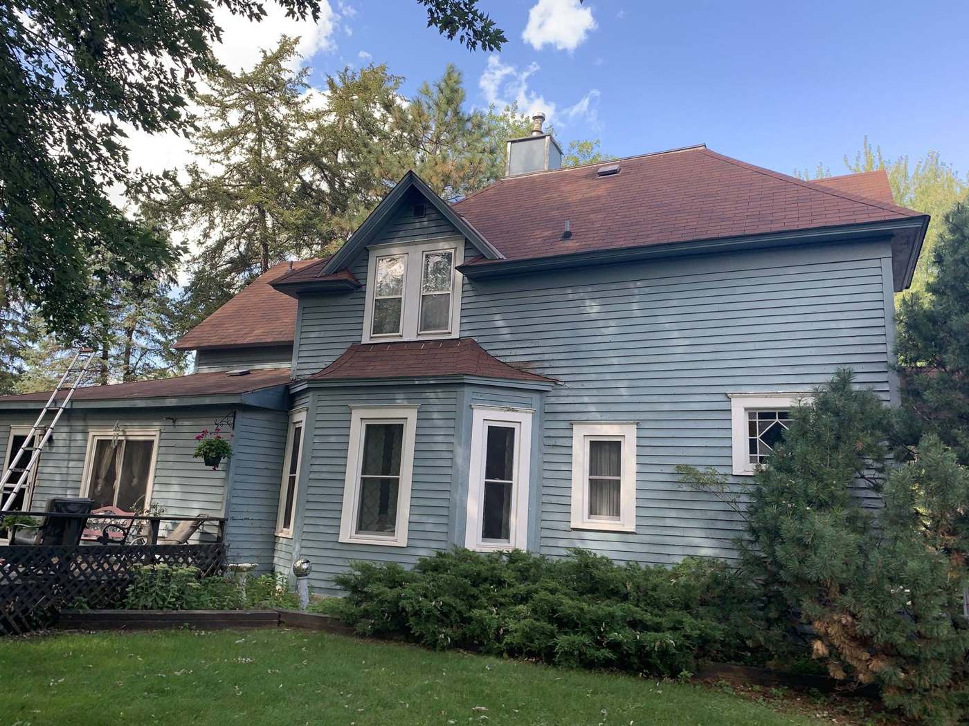 Two-story blue clapboard home with a steep shingle roof in Watertown, MN, inspected by Repair King