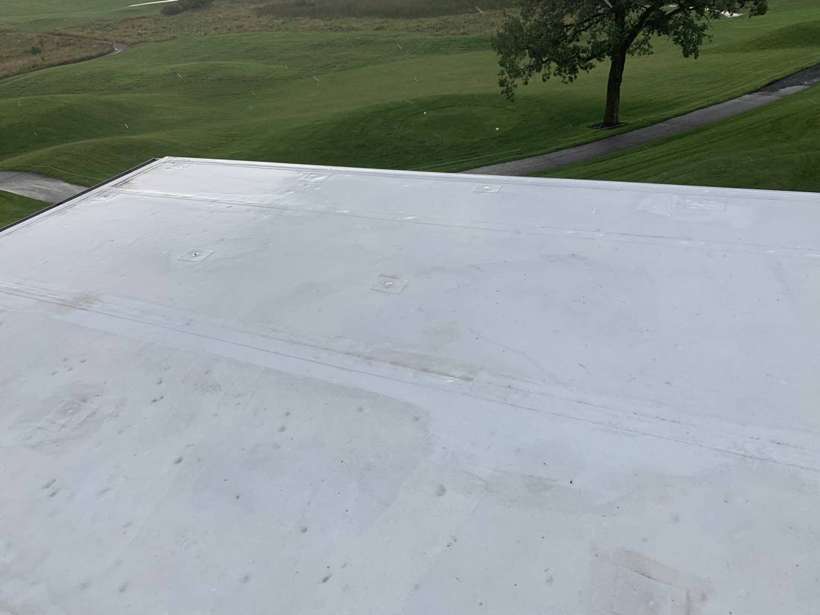 White Duro-Last flat roof on the Coyote Moon Grille clubhouse, with the golf course behind, St. Cloud